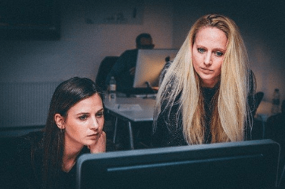 Two women looking at computer to research ghostwriter