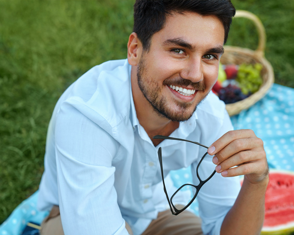 man covering face with both hands while sitting on bench